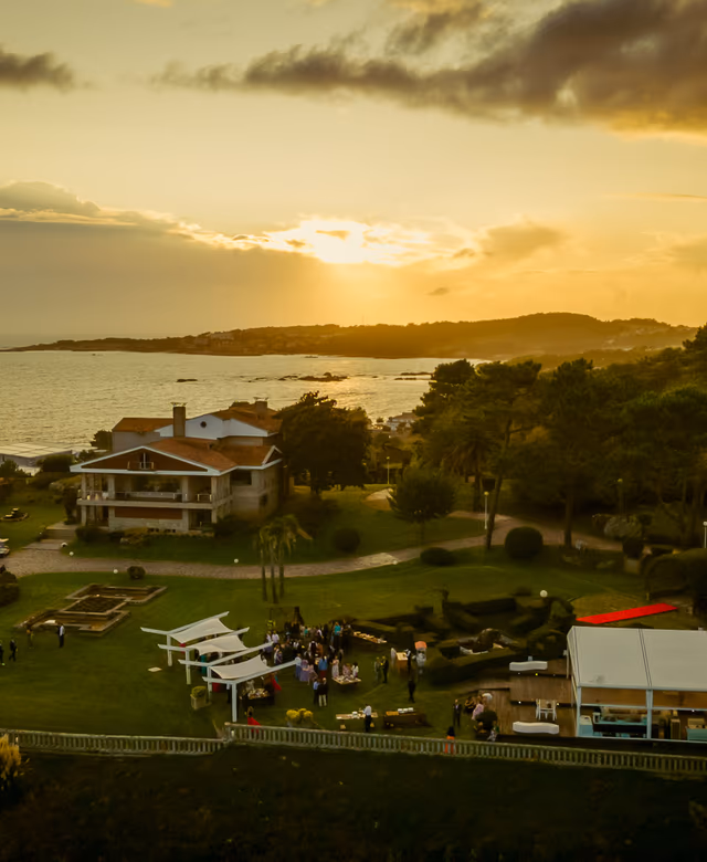 Jardines de Finca La Atlántida al atardecer con mesas de aperitivo y el mar al fondo