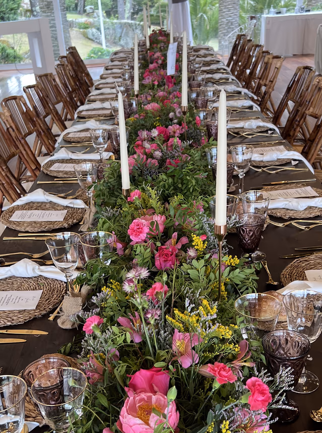 Mesa imperial vestida con flores silvestres y velas en el salón de Finca La Atlántida