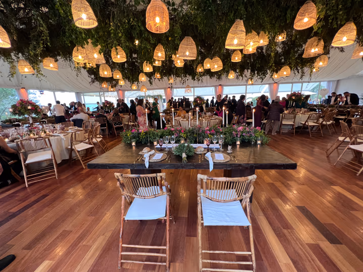 Salón panorámico de Finca La Atlántida en plena celebración, con lámparas de ratán